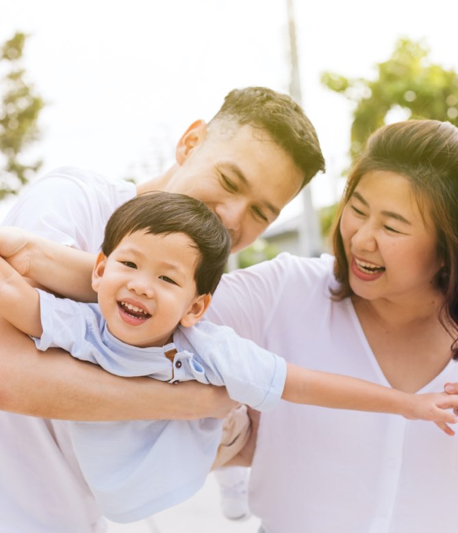 family carrying son outside